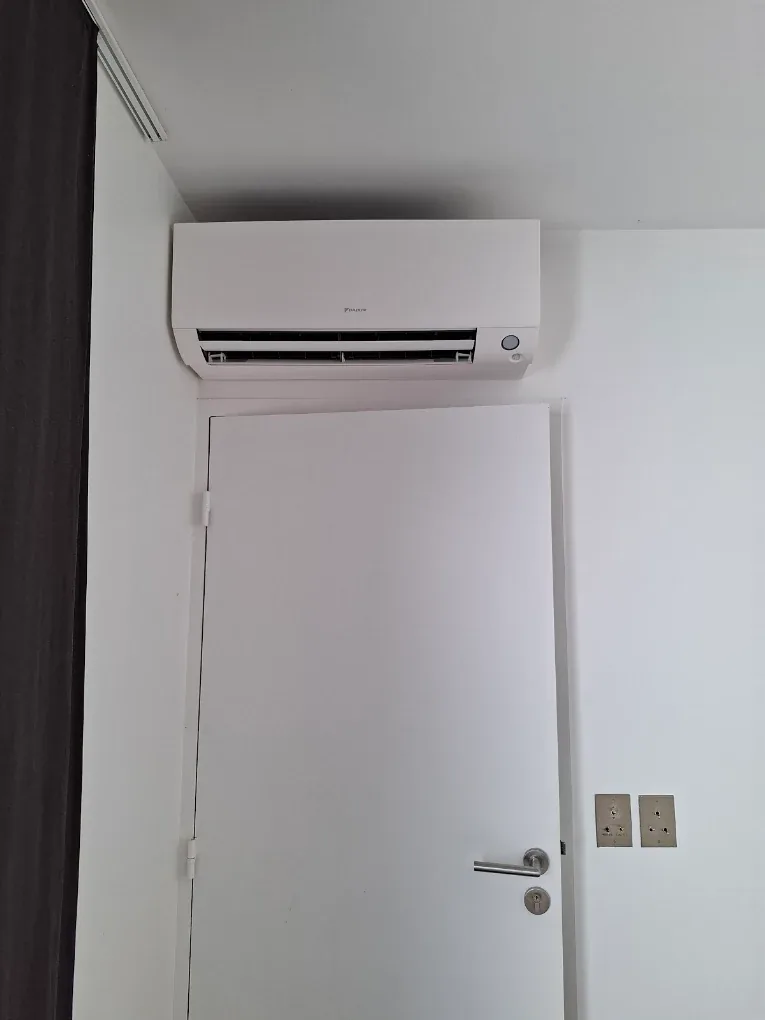 Climatisation réversible installée au-dessus d'une porte