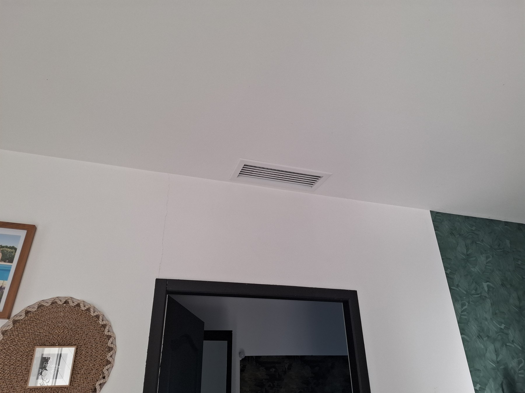 Bouche de diffusion d'une climatisation gainable installée au plafond d'un salon